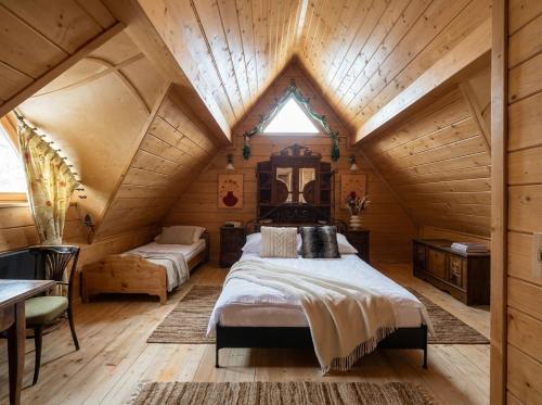 a bedroom with a large bed in a wooden house at Golden Tatra Chalet - Fireplace, Sauna & Garden in Zakopane