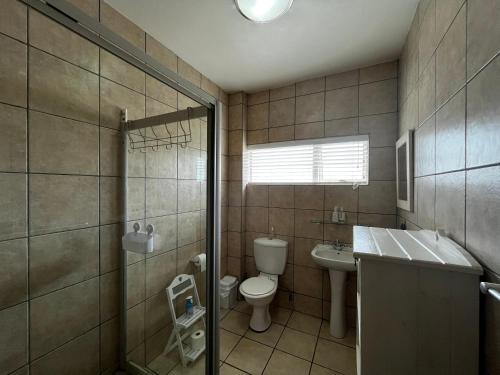 a bathroom with a toilet and a sink and a shower at La Palma Villa 8 in Mossel Bay