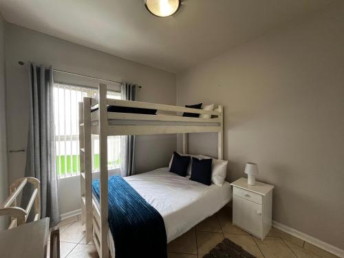 a bedroom with a bunk bed and a window at La Palma Villa 8 in Mossel Bay