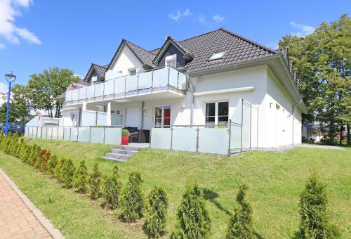 a white house on a hill with christmas trees at Haus Sonne - Whg 08 in Thiessow