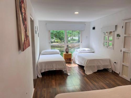 two beds in a white room with a window at Marine Beach Hotel in Cartagena de Indias