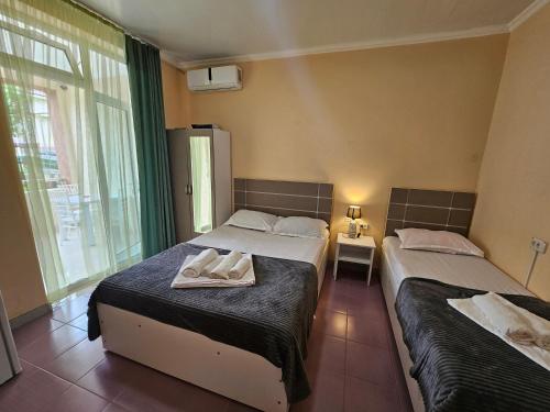 a bedroom with two beds with towels on them at Imeri Hotel in Ureki