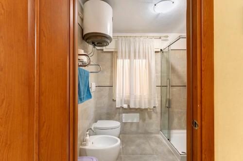a small bathroom with a toilet and a shower at Attico Bella Vista in Siniscola