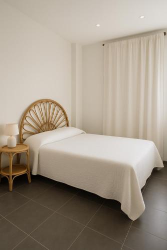 a white bedroom with a large bed and a table at Holidays in Sainte-Maxime