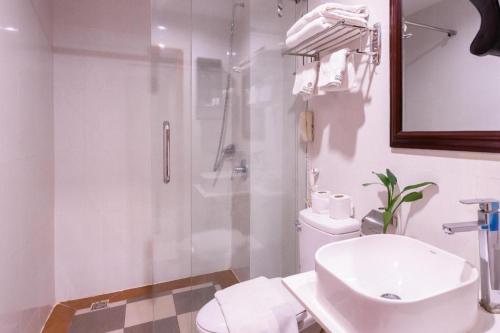 a bathroom with a shower and a toilet and a sink at Wind Holiday Hotel in Phnom Penh