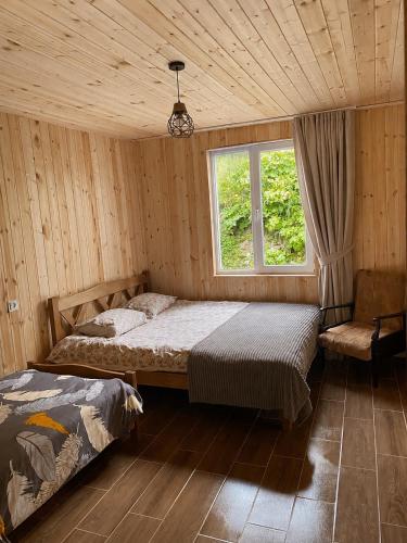 a bedroom with two beds and a window at Zhorzholiani House - Betkili in Lakhiri