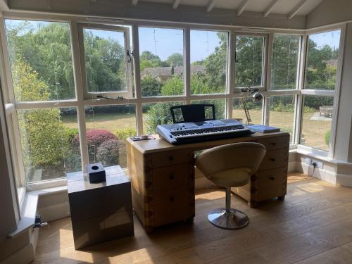 an office with a computer on a desk in front of a window at The Annexe, Cleveley Mill in Chipping Norton