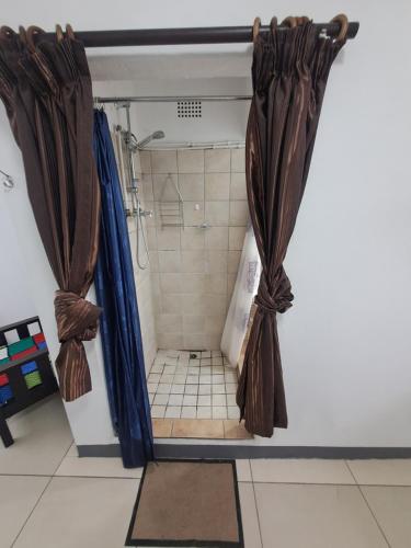 a shower with brown curtains in a bathroom at The haven in George