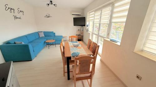 a living room with a blue couch and a table at Moni Sunset Apartment Balchik in Balchik