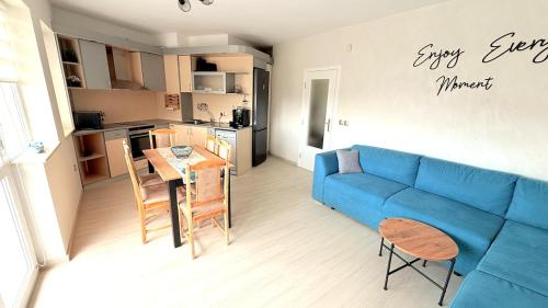 a living room with a blue couch and a table at Moni Sunset Apartment Balchik in Balchik