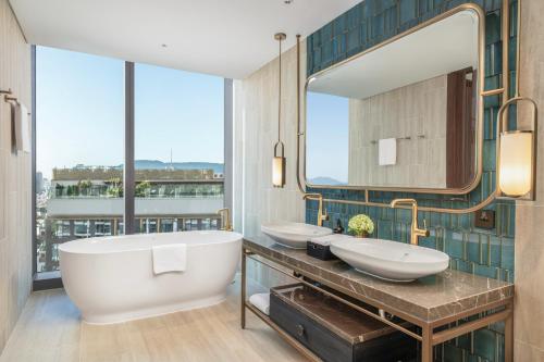 a bathroom with two sinks and a large window at TUI BLUE Han River in Danang