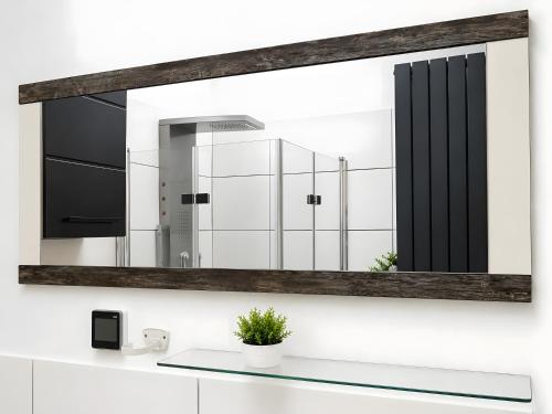 a mirror on a wall above a bathroom sink at Apartment 202 in Bernau bei Berlin
