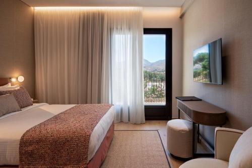a hotel room with a bed and a window at Hotel Delfinia in Mythimna