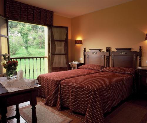 a bedroom with two beds and a large window at Hotel Camangu in Camango
