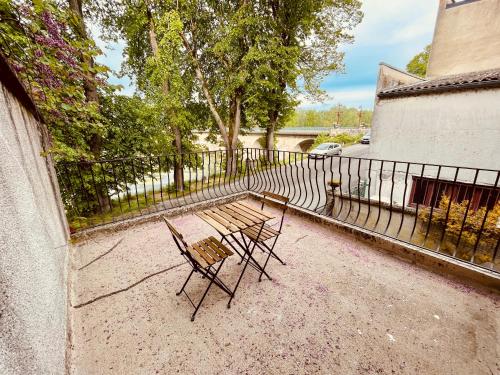 a bench and a chair in front of a fence at Le Bivouac en Orient - Home Homy in Saint-Florent-sur-Cher