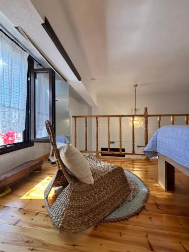 a room with a bed and a rattan chair at To Katinaki in Trikeri