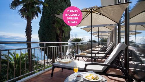 a row of tables and chairs on the balcony of a hotel at Hotel Kristal - by Liburnia Hotels & Villas in Opatija