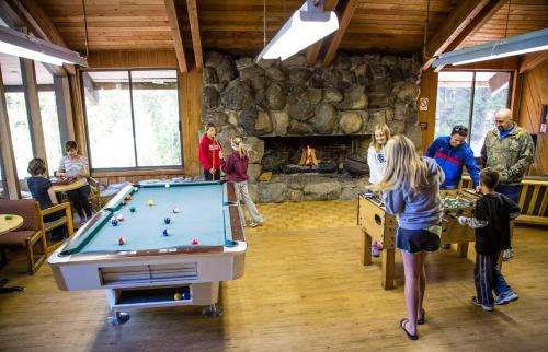 a group of people standing around a pool table at Snowflower Camping Resort 12 ft. Yurt 9 in Emigrant Gap