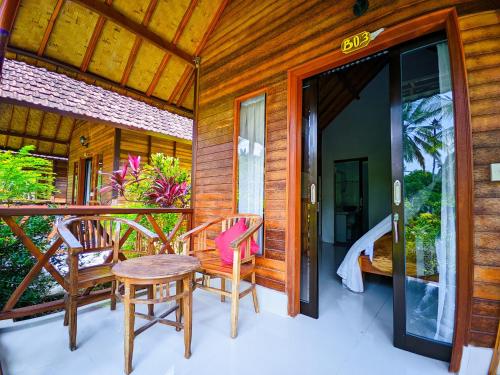 a patio with a table and chairs on a porch at Dangin Kubu Pedoman in Toyapakeh