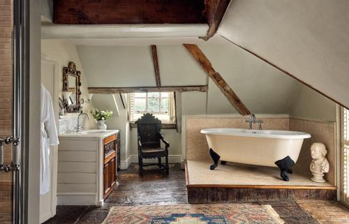 a bathroom with a bath tub and a sink at Chilston Park Hotel in Maidstone