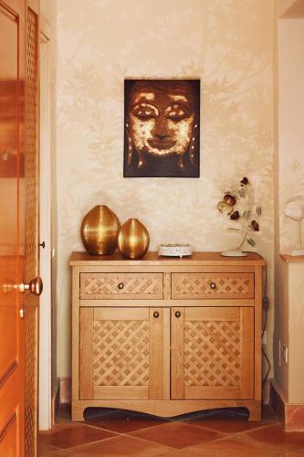a wooden cabinet in a room with a picture on the wall at Villa Myrtos - 300mt dal mare in Chia
