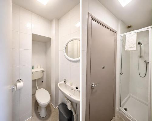 a white bathroom with a toilet and a shower at Hampton Hotel in Llandrindod Wells