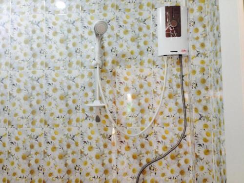 a shower with a shower curtain with yellow flowers at MAIYOK in Ko Si Chang