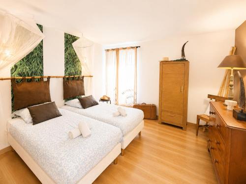 a bedroom with two beds and a dresser at Apt duplex ou plain pied tout confort plein centre ville Bayeux proche commerces, restaurants, avec terrasse privative ou jardin commun aménagé clos, parking gratuit à proximité, proche plages du débarquement in Bayeux