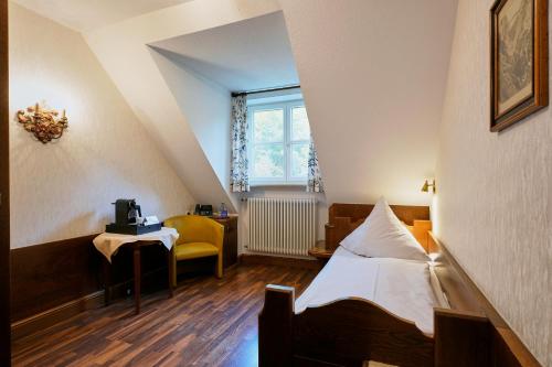 a room with a bed and a table and a window at Hotel Müller in Hohenschwangau
