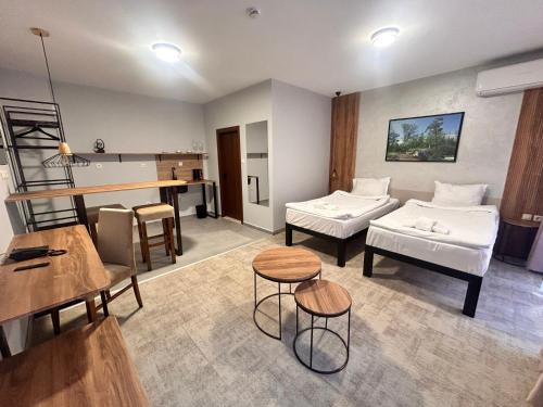 a room with two beds and a table and chairs at Clepsydra Residence in Plovdiv