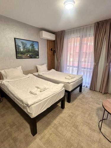 a hotel room with two beds and a window at Clepsydra Residence in Plovdiv