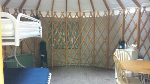 a room with a tent with a table and chairs at Snowflower Camping Resort 16 ft. Yurt 10 in Emigrant Gap