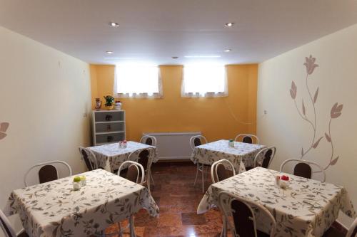 a room with two tables with white table cloth at Zita Haus in Bük