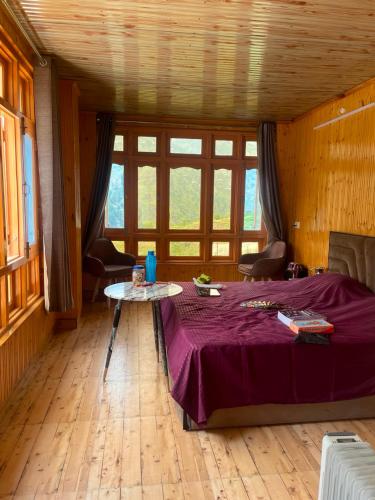 a room with a table with a purple bed in it at DELTA Inn HOMESTAY in Khashdhār