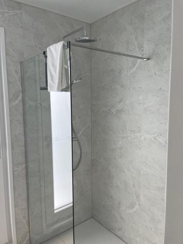 a shower with a glass door in a bathroom at Waddenlodge Exclusive in Harlingen