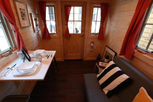 Cette chambre comprend une table, un canapé et des fenêtres. dans l'établissement Verde Valley Tiny House 18, à Cottonwood