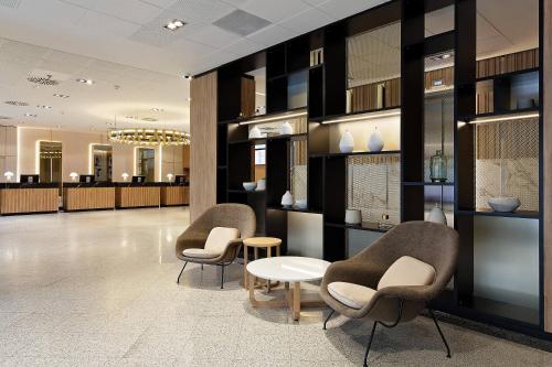 a lobby with three chairs and a table and a waiting room at Meliá Avenida América in Madrid