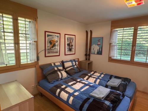 a bedroom with a bed in a room with windows at Tgèsa Staziun in Sedrun