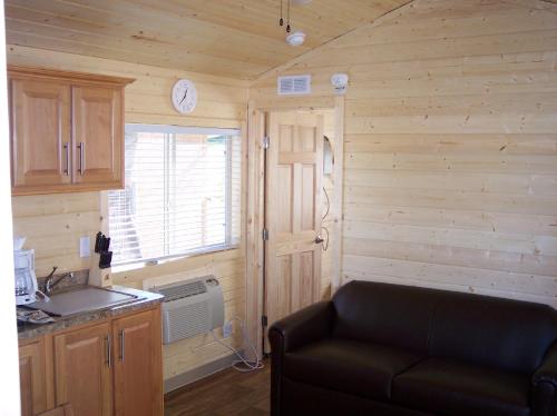 ein Wohnzimmer mit einer Couch in einem winzigen Haus in der Unterkunft Russian River Camping Resort Cottage 9 in Cloverdale