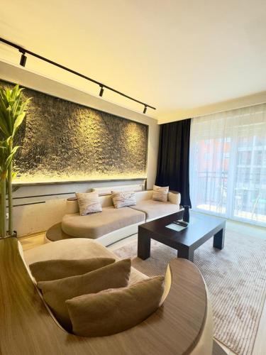 a living room with two beds and a table at Prishtina Escape Apartments - Luxury & Modern Apartment in Prishtinë
