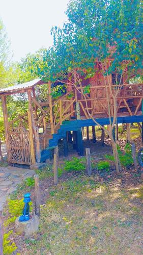 a wooden playground with a blue bench in a park at Essie Rovers Camp in Talek