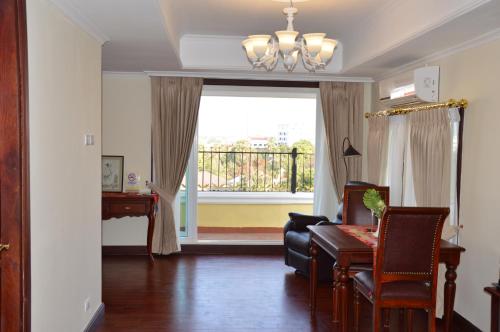 a living room with a desk and a large window at Phasouk Vien Chantra Hotel in Vientiane