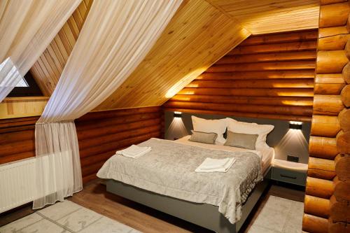 a bedroom with a bed in a room with wooden walls at Готель Кумир in Rivne