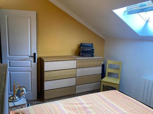 a bedroom with a bed and a dresser and a window at La Maisonnette in Les Andelys