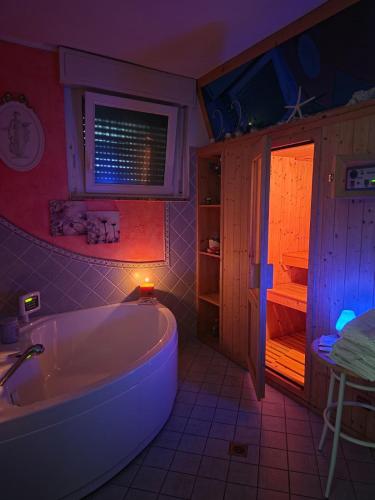 a bathroom with a tub and a table and a window at HOTEL AURORA in Cattolica