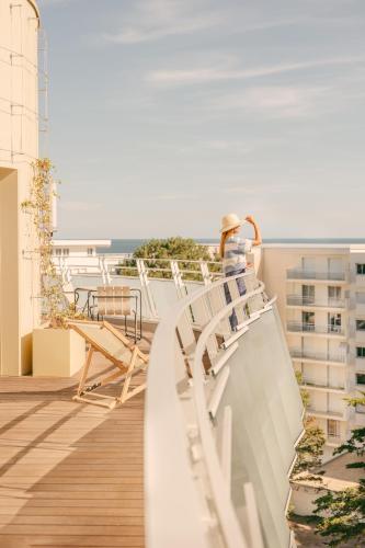 a person sitting on the balcony of a building at Les Cimes Bleues in La Baule