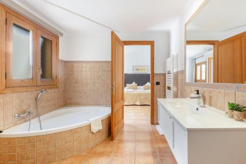a bathroom with a tub and a sink at Casa Horta Den Menut in Pollença