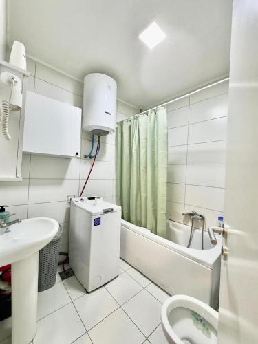 a bathroom with a sink and a toilet and a bath tub at Prishtina Escape Apartments - Luxury & Modern Apartment in Prishtinë