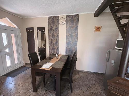 a dining room with a wooden table and chairs at Vank Apartman Barcs in Barcs