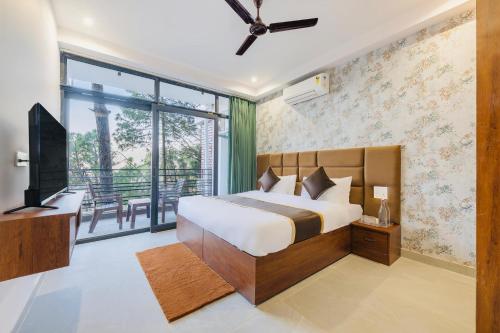 a bedroom with a bed and a tv and a balcony at Dream Haven Kasauli in Kasauli